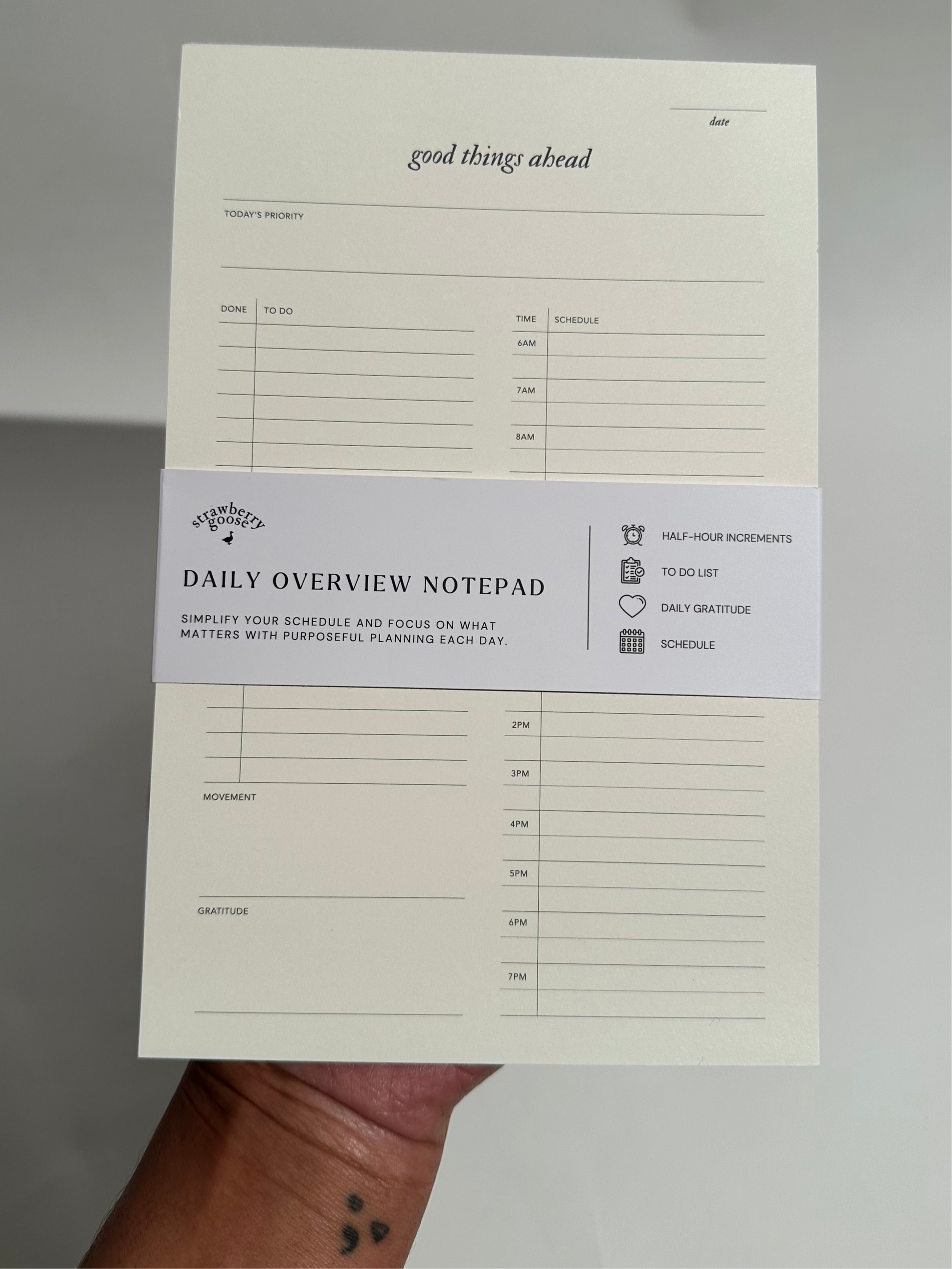 A Daily Notepad with 30-minute increments for scheduling, a to-do list for tasks, daily reflections, and a space to track daily movement and top priority.