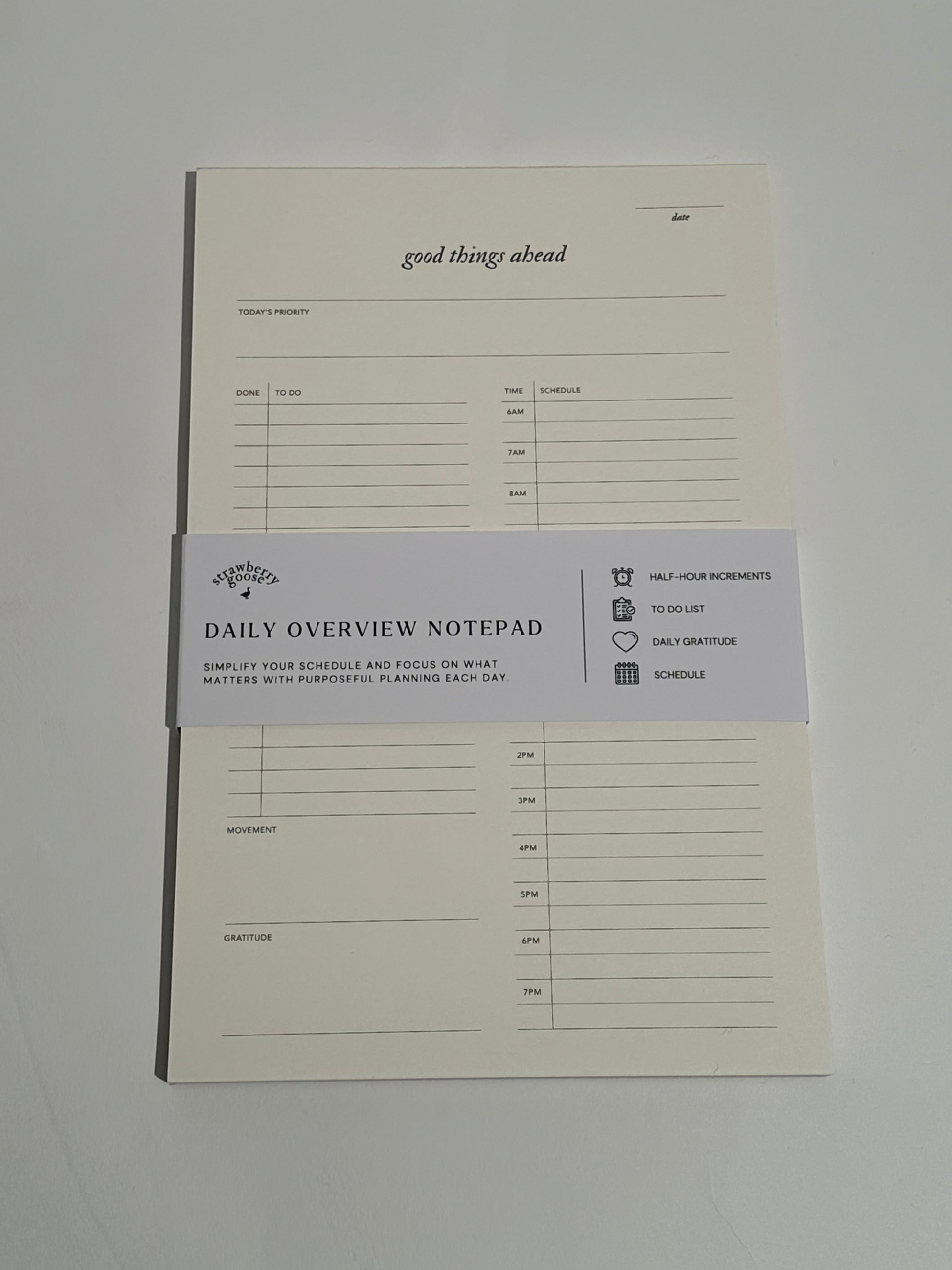 A Daily Notepad with 30-minute increments for scheduling, a to-do list for tasks, daily reflections, and a space to track daily movement and top priority.